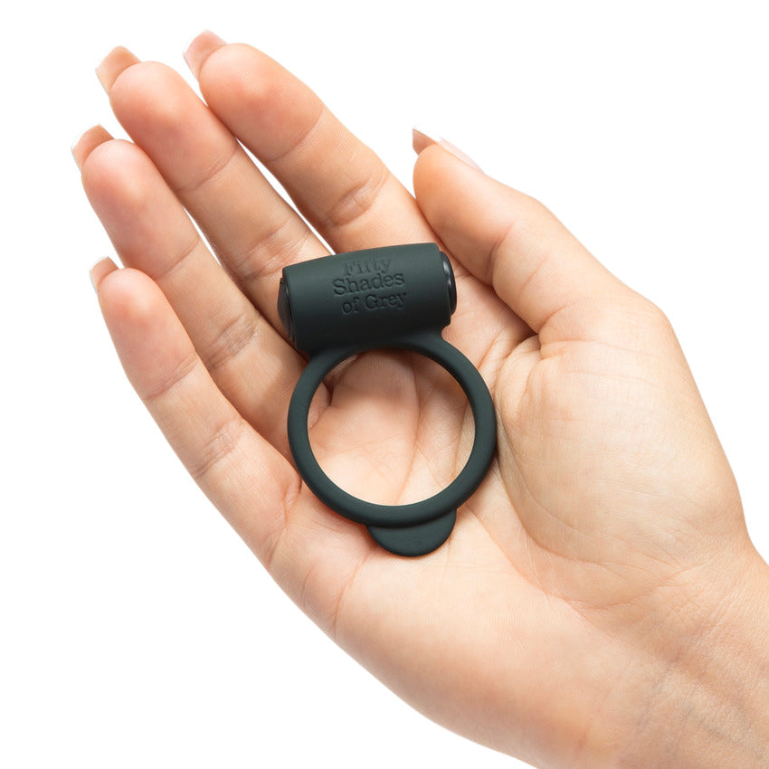 An open palm has the Fifty Shades of Grey Yours and Mine dropped into it. The cock ring looks slender and simple in their hand. It looks lightweight and easy to use. | Kinkly Shop