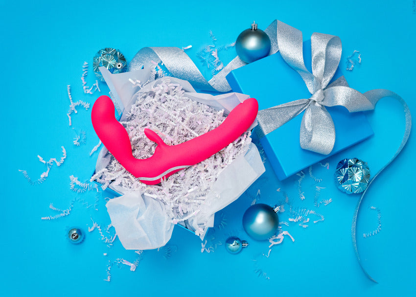 The Happy Rabbit Strapless Strap on Rabbit shown resting on top of an open gift box, looking very festive. | Kinkly Shop