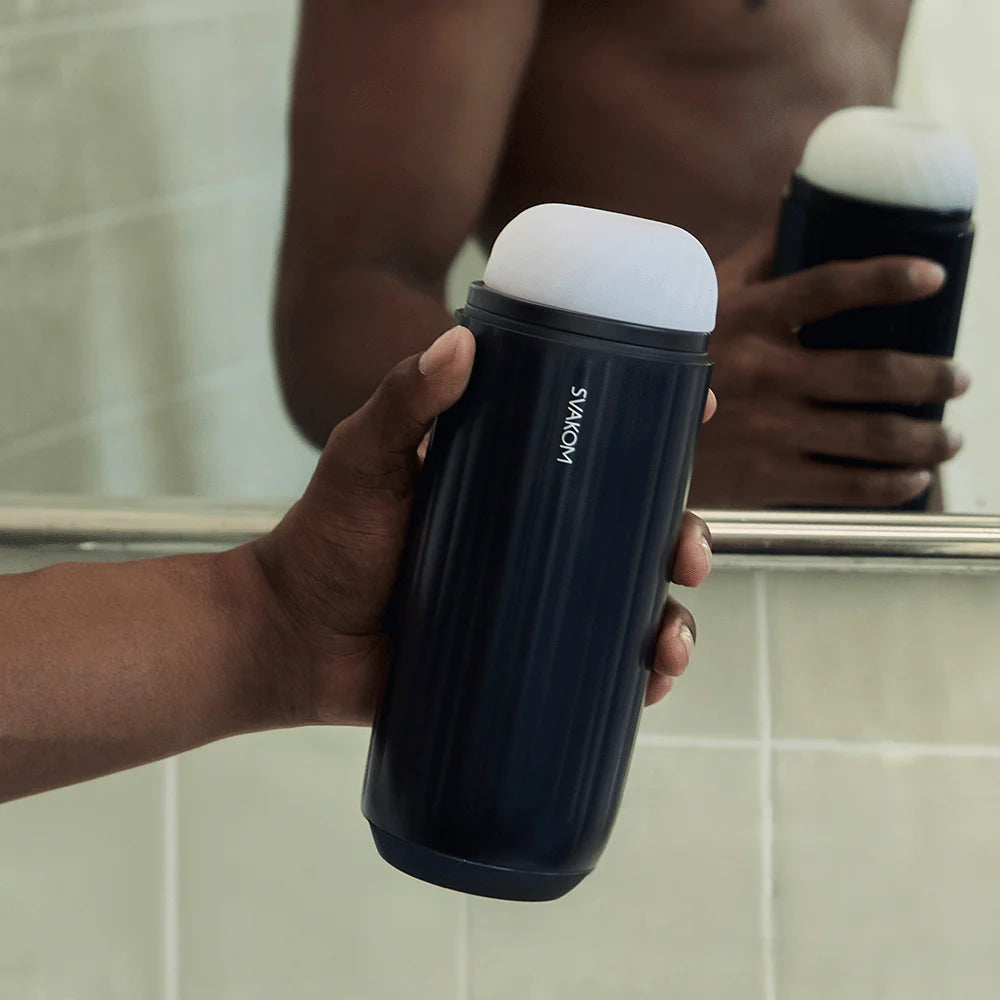 A person holds the Svakom Sam Neo in front of a mirror. The stroker looks somewhat thick to grasp. | Kinkly Shop