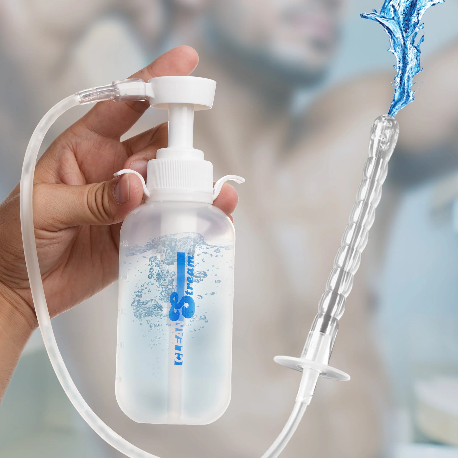 A hand holds the CleanStream Pump Action Enema Bottle, showcasing the two on-cap lips that make it easier to hold between the pinky finger and the thumb. | Kinkly Shop