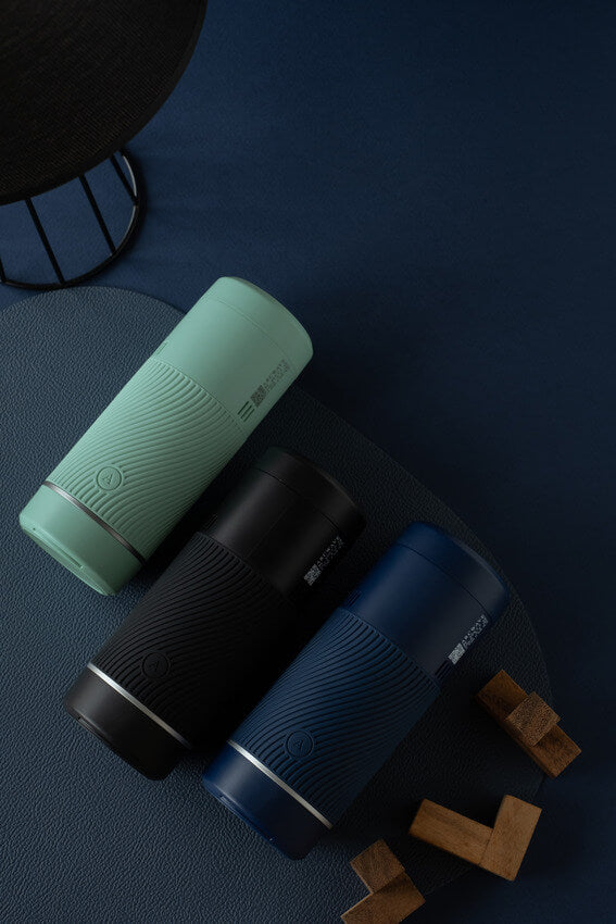 All three colors of the Arcwave Pow lay out on top of a dark blue table. They contrast against each other beautifully, and it looks like this could be an ad for three Bluetooth speakers. | Kinkly Shop