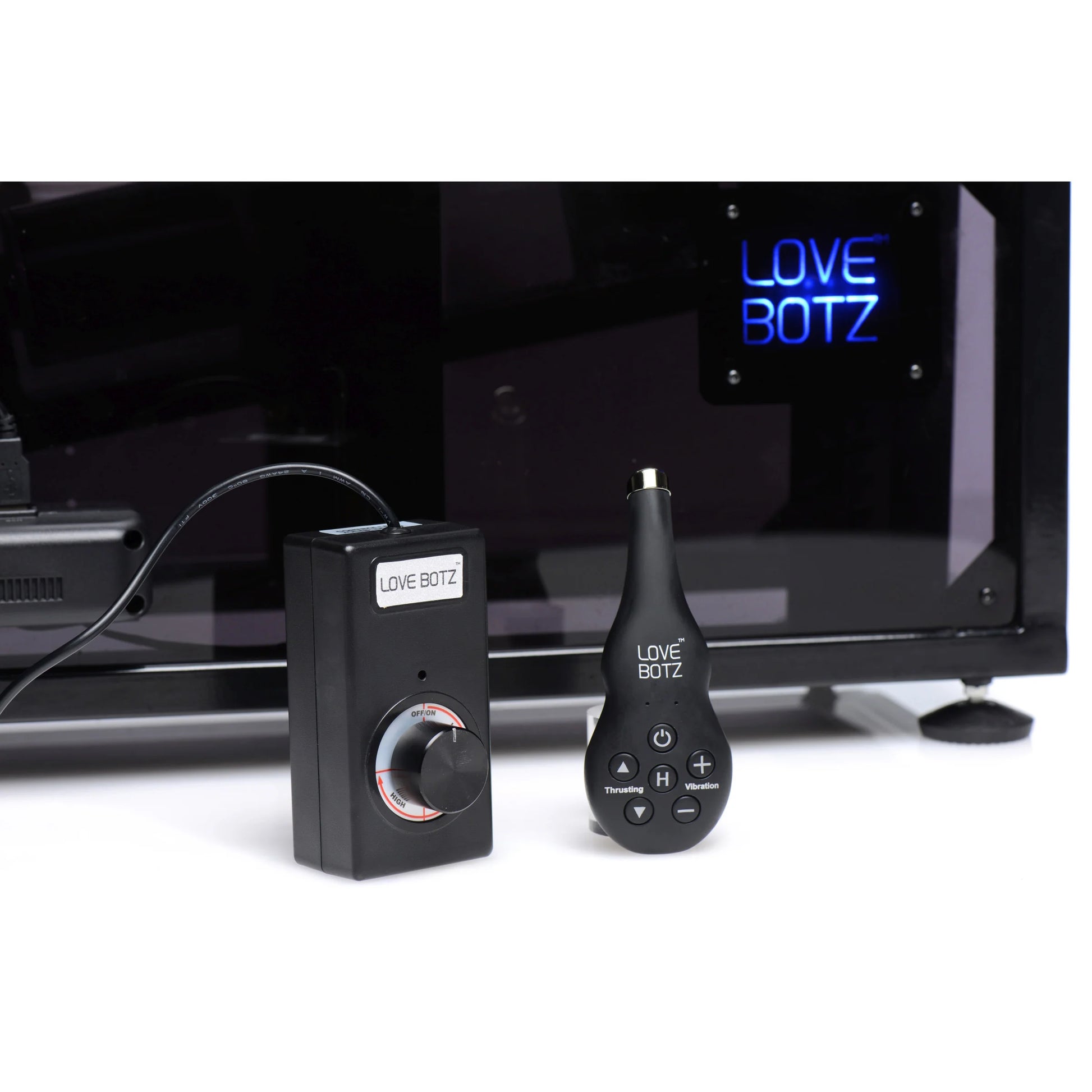 Close-up on the two remotes included with the Athena's Ultimate Sex Machine. One is corded and the other is cordless. | Kinkly Shop