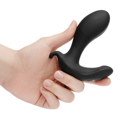 A hand holds the b-Vibe Expand. The plug looks L-shaped with a relatively slender thickness that looks about the width of a biological penis. | Kinkly