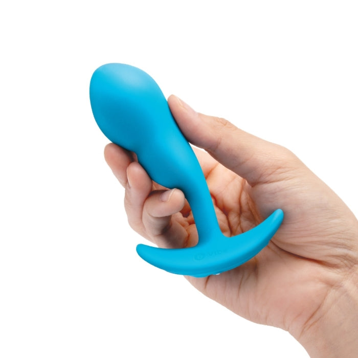 A hand holds the B-Vibe Remote Control P-Spot Snug Plug in blue. This is the smaller and lighter of the two plugs. | Kinkly Shop
