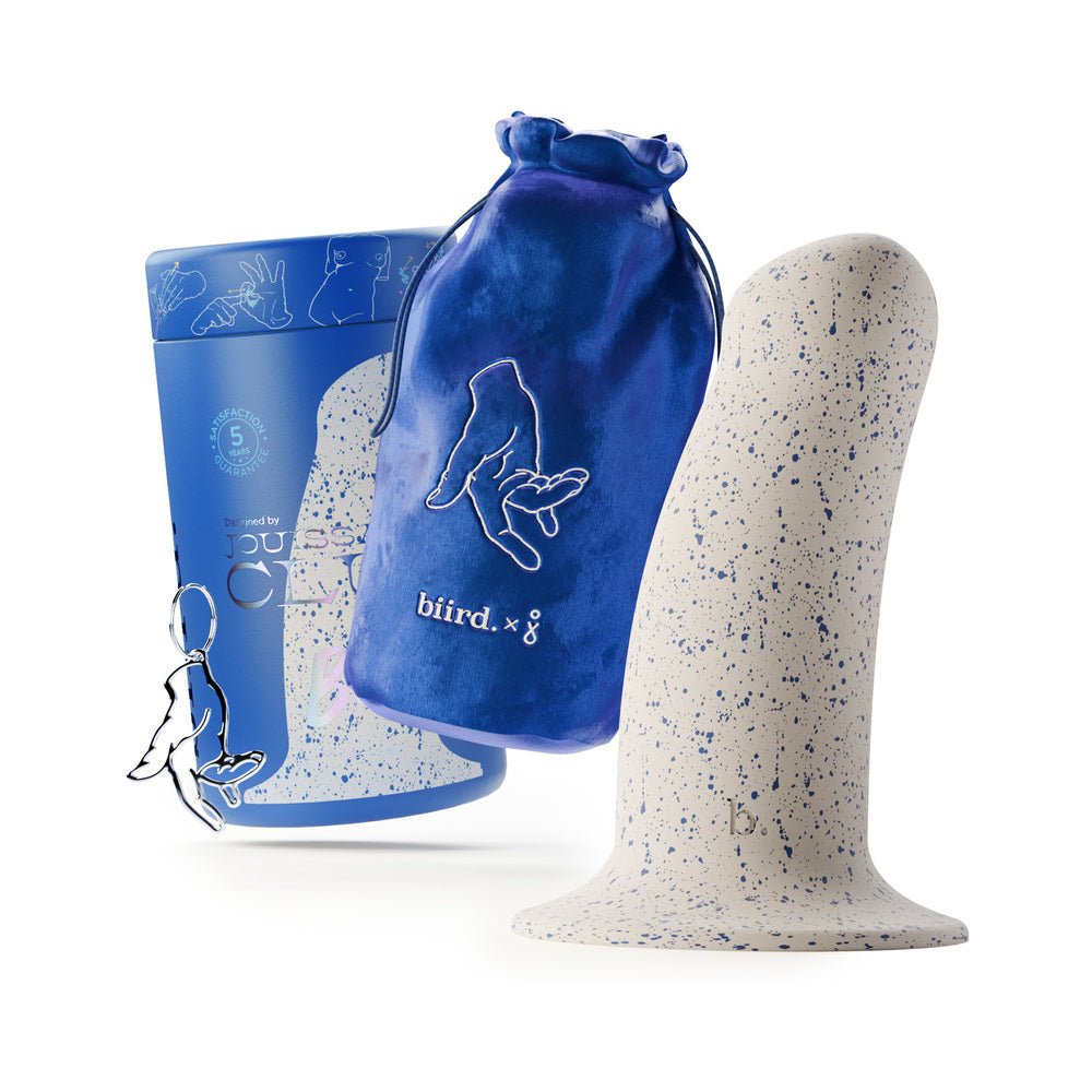 The Biird Boo next to everything it comes with. There's the cylindrical packaging, a fingering charm keychain, and a blue drawstring bag with the Biird logo. | Kinkly Shop