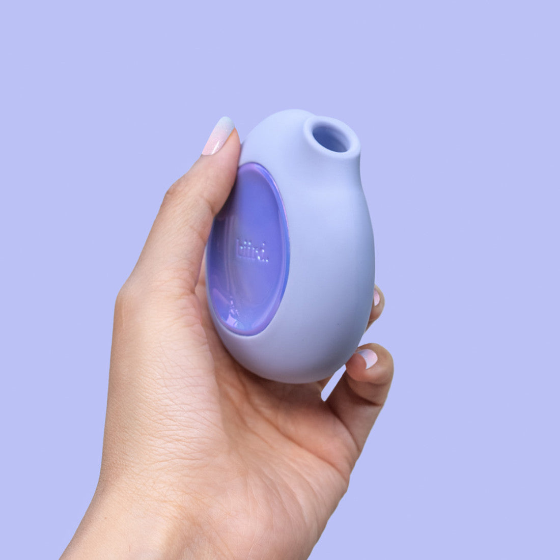 A hand holds the Biird Lumii. The vibrator is circular but slim, and it looks easy to grip. | Kinkly Shop
