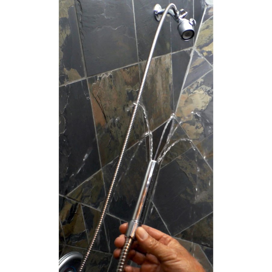 A person is holding the thick spray nozzle from the CleanStream Beginner Shower Enema Set while it's turned on, showcasing the water coming out from the tip. | Kinkly Shop