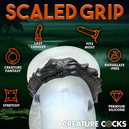 The Creature Cocks Caiman shown wrapped around a clear realistic dildo. Icons and text surround the ring. Text reads: Last longer, creature fantasy, stretchy, fits most, phthalate-free, and premium silicone. | Kinkly Shop