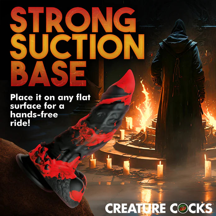 The Creature Cocks Fire Demon shown adhered to a large bolder. Text on the image reads: Strong suction base. Place it on any flat surface for a hands-free ride. | Kinkly Shop