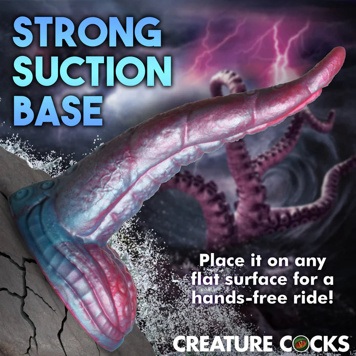 The Creature Cocks Tentacle shown suction cupped to an ocean rock. Text reads: Strong suction base. Place it on any flat surface for a hands-free ride. | Kinkly Shop