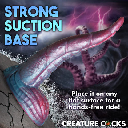 The Creature Cocks Tentacle shown suction cupped to an ocean rock. Text reads: Strong suction base. Place it on any flat surface for a hands-free ride. | Kinkly Shop