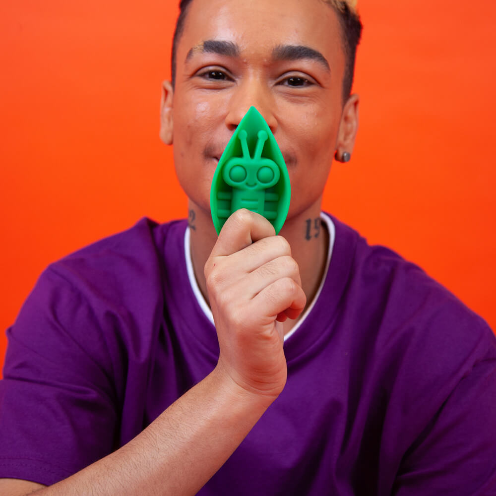 A close-up on a person's face. They are holding the Cute Little Fuckers Zeep in front of their mouth. The Zeep's width almost blocks out all of their lips. The Zeep extends from the person's chin all the way up to mid-way up their nose in length. | Kinkly Shop