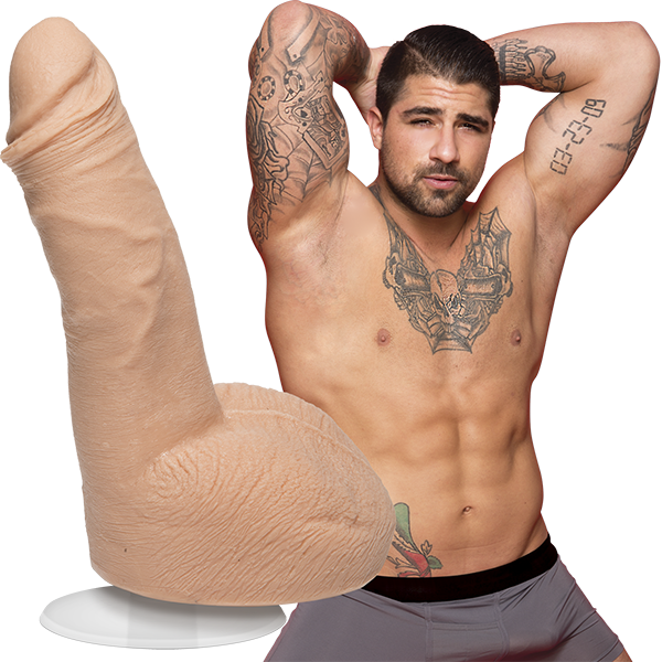 A shirtless Ryan Bones looks into the camera while wearing boxer briefs. The Signature Cocks - Ryan Bones dildo lifecast from the porn star is shown next to the porn star. | Kinkly Shop
