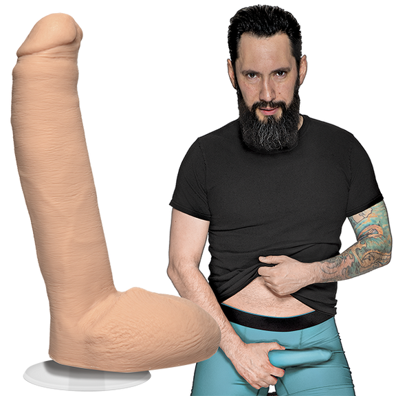 Tommy Pistol is looking into the camera while holding his erection that's in his boxer briefs. The Signature Cocks - Tommy Pistol dildo is shown next to the porn star, lifecast and modeled directly from him. | Kinkly Shop