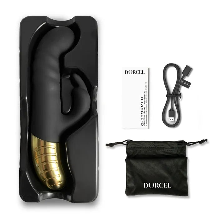 The Dorcel G-Stormer Thruster shown next to everything it comes with. It includes the charging cable, instructions, sex toy itself, and a black drawstring storage bag. | Kinkly Shop