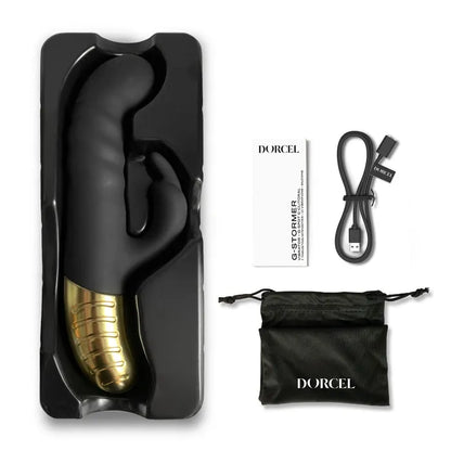 The Dorcel G-Stormer Thruster shown next to everything it comes with. It includes the charging cable, instructions, sex toy itself, and a black drawstring storage bag. | Kinkly Shop