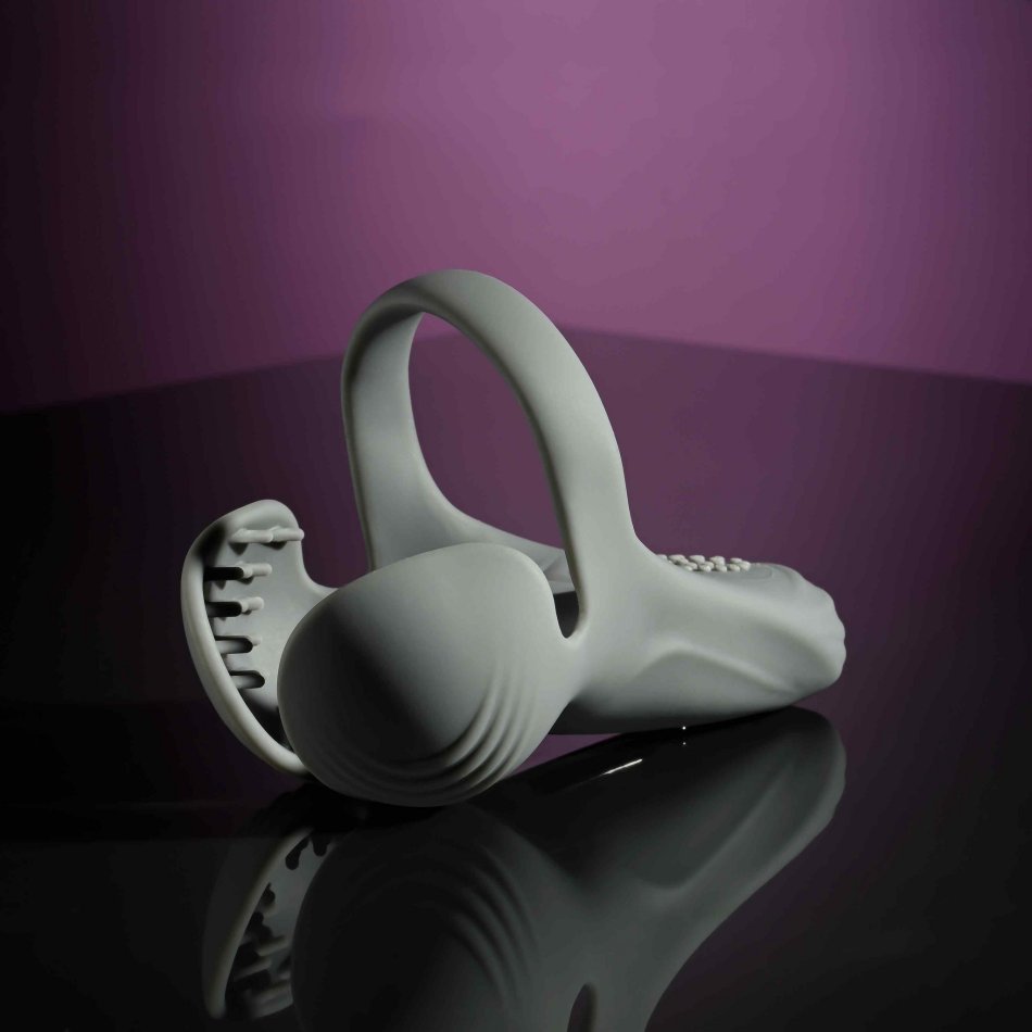 The Evolved Undercarriage lays out on a black, shiny table. The entire toy holds its shape well, even while lying down, showcasing the flexible - yet firm - silicone material that makes up the shape of the Evolved Undercarriage | Kinkly Shop