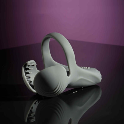 The Evolved Undercarriage lays out on a black, shiny table. The entire toy holds its shape well, even while lying down, showcasing the flexible - yet firm - silicone material that makes up the shape of the Evolved Undercarriage | Kinkly Shop