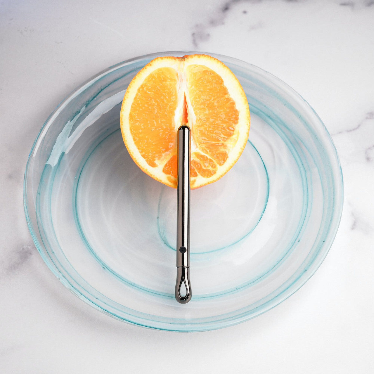 The Evolved Pen Pal rests on top of a cut-in-half orange. It looks super slender, and it is slim enough to still showcase the rind around the vibe. | Kinkly