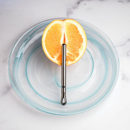 The Evolved Pen Pal rests on top of a cut-in-half orange. It looks super slender, and it is slim enough to still showcase the rind around the vibe. | Kinkly