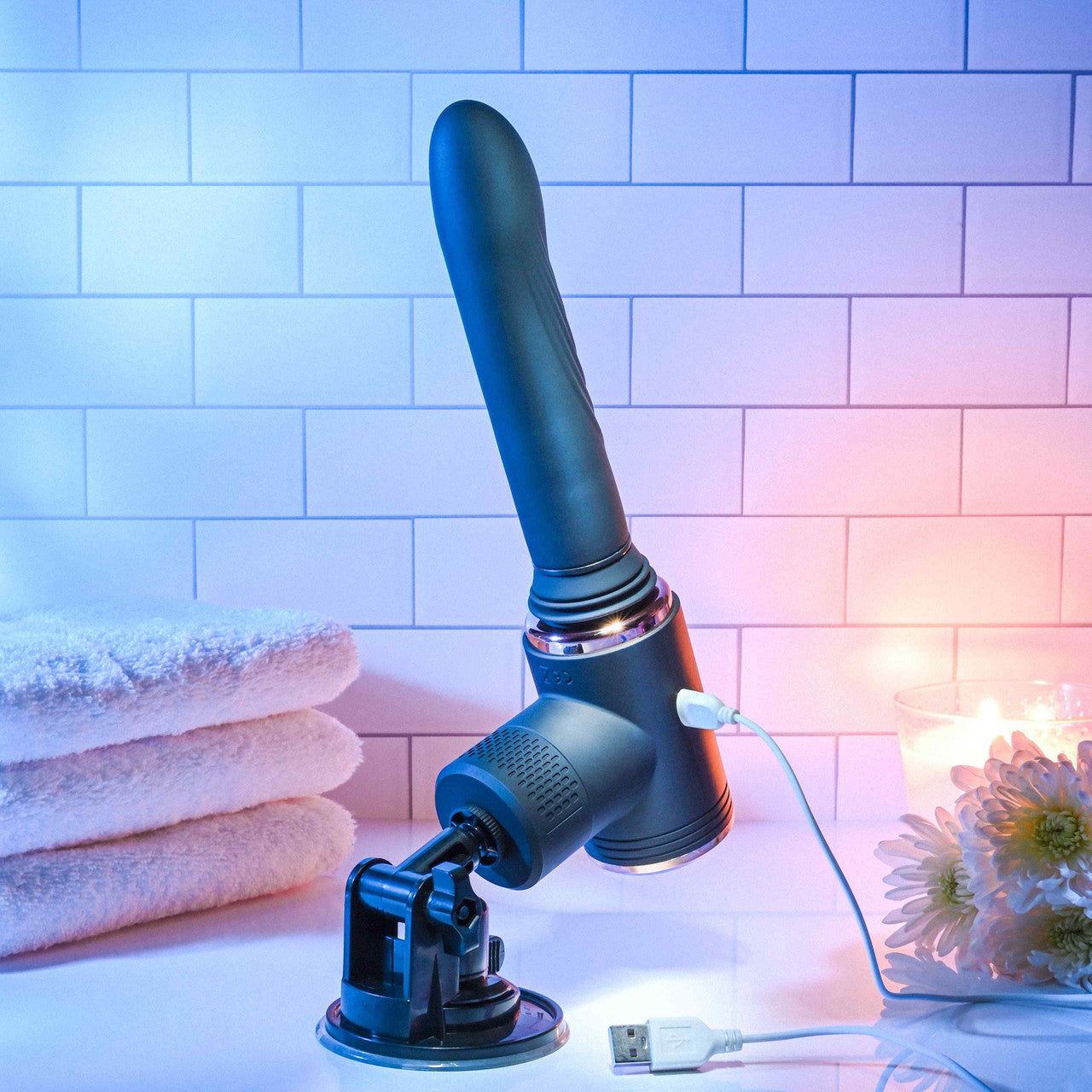 The Evolved Too Hot to Handle Thrusting Machine is plugged into the charger and charging. The suction cup holds it upright. | Kinkly Shop