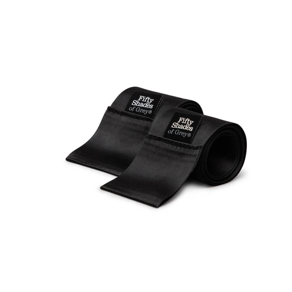 A close-up of the two black satin restraint ties with the Fifty Shades of Grey branding tags on them. | Kinkly Shop