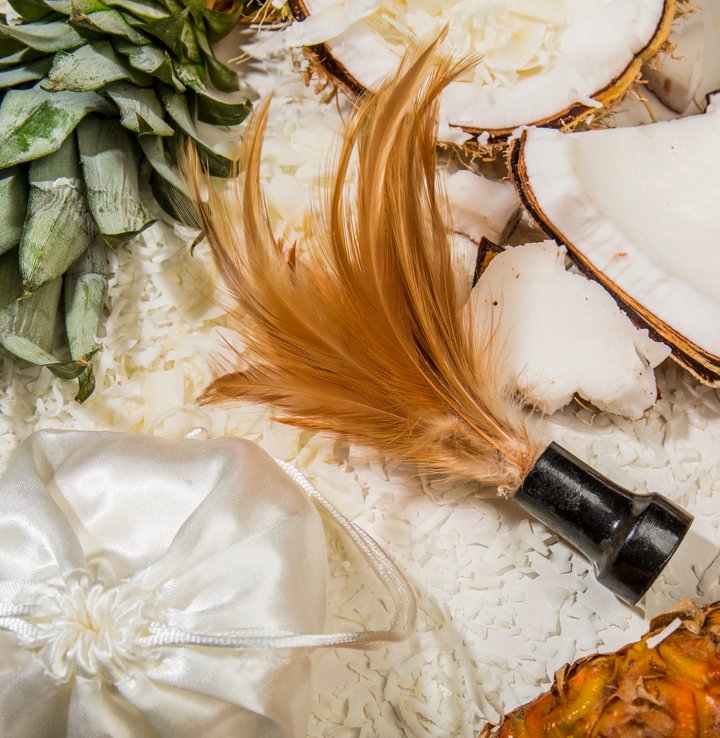 The included feather, with its handle, shown laying out next to decorative objects. | Kinkly Shop