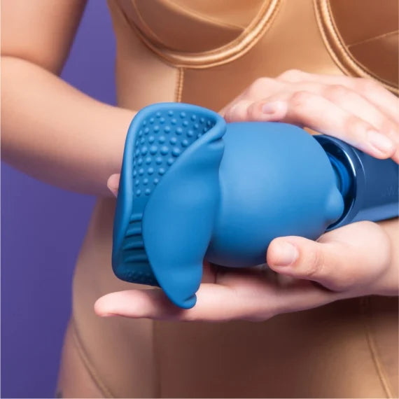 Le Wand Stroke Attachment shown on top of a wand massager. The textured nodules and ribbed interior are easily visible in the bright light. | Kinkly Shop