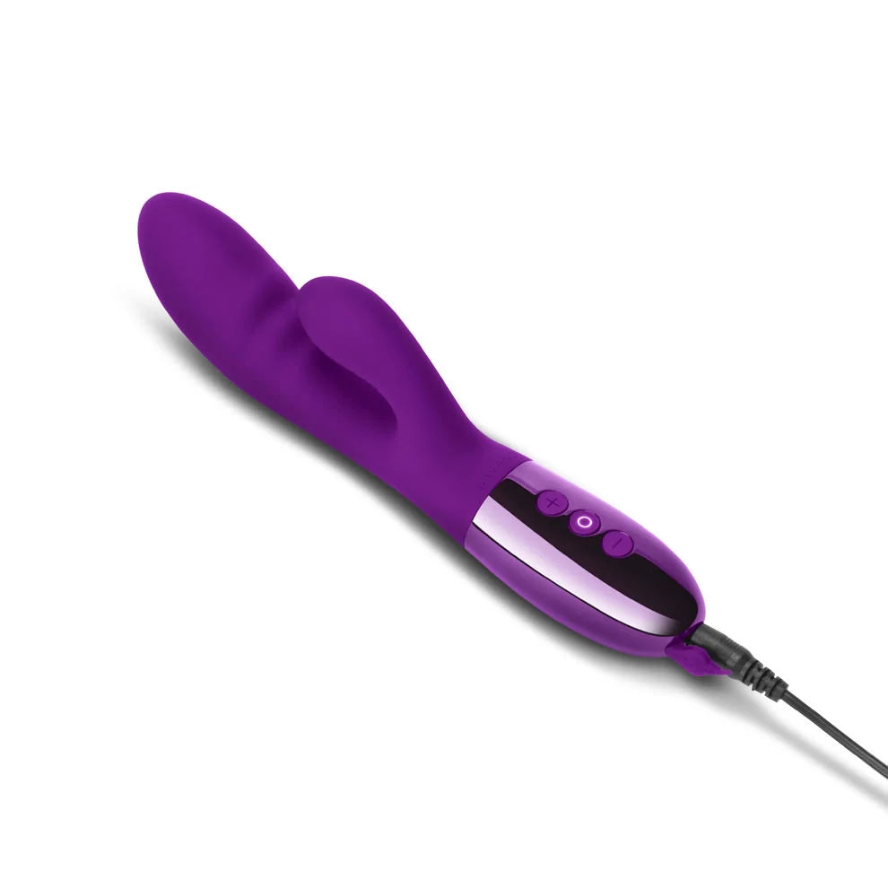 The Le Wand Blend vibrator plugged in to charge. The charging cable plugs in at the base of the vibrator within the splashproof charging door that needs to be opened to charge it. | Kinkly Shop