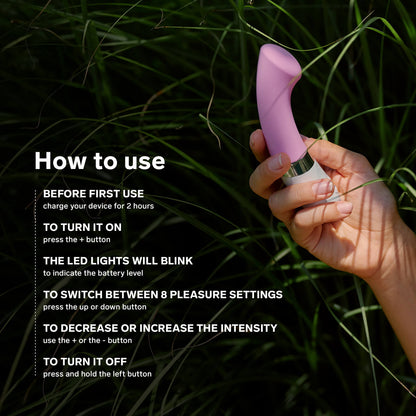 A hand holds the LELO GIGI 2 in some tall grass. Text on the image reads: "How to use. Before first use, charge your toy for 2 hours. To turn it on, press the + button. The LED lights will blink to indicate the battery level. To switch between 78 pleasure settings, press up or down. To decrease or increase intensity, use + or -. To turn it off, press and hold the left button." | Kinkly Shop