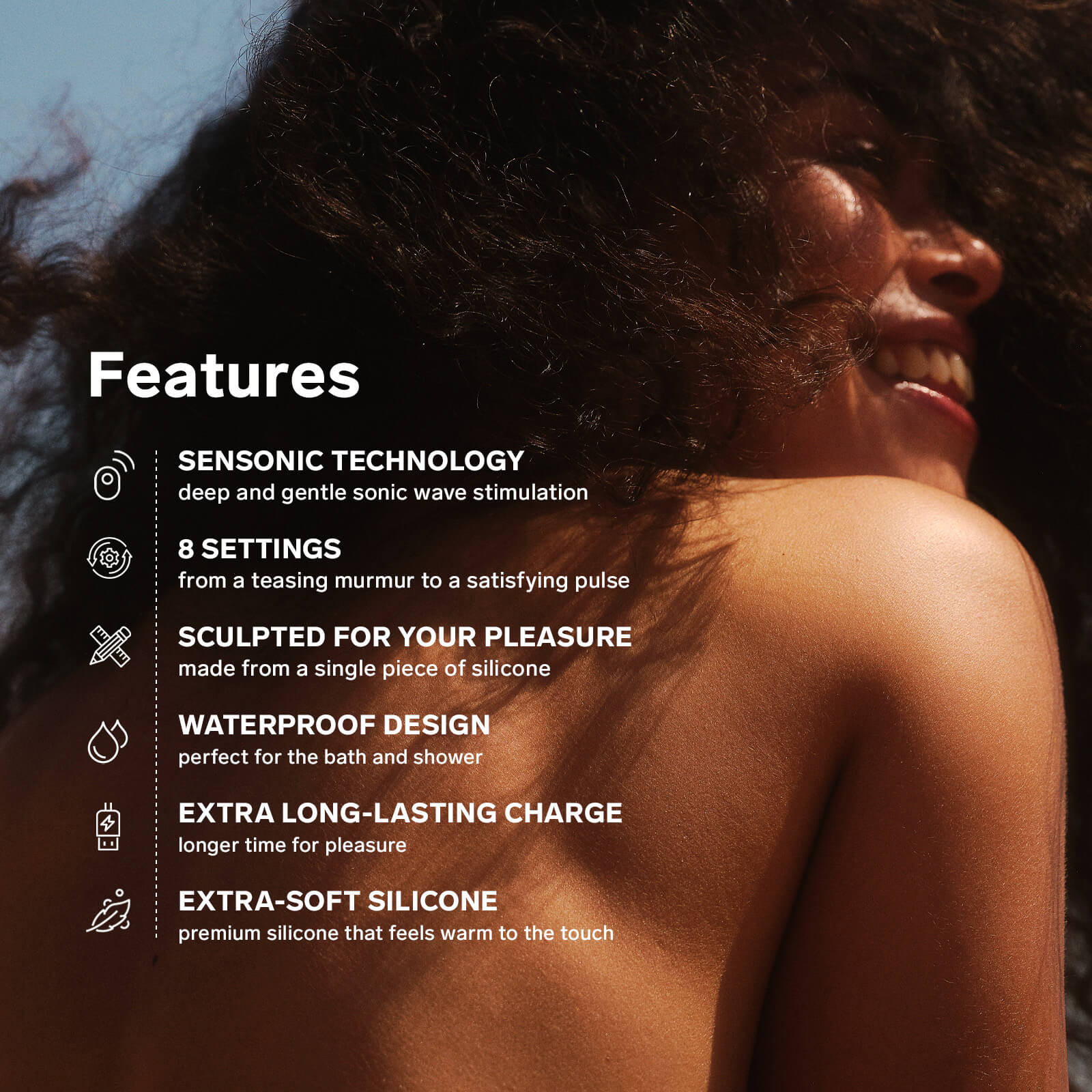 A person smiles into the sunset. Written on their bare back in text are features including: "Sensonic technology. Deep and gentle sonic wave stimulation. 8 Settings from a teasing murmur to a satisfying pulse. Sculpted for your pleasure made from a single piece of silicone. Waterproof design perfect for the bath and shower. Extra long-lasting charge longer time for pleasure. Extra-soft silicone that feels warm to the touch." | Kinkly Shop