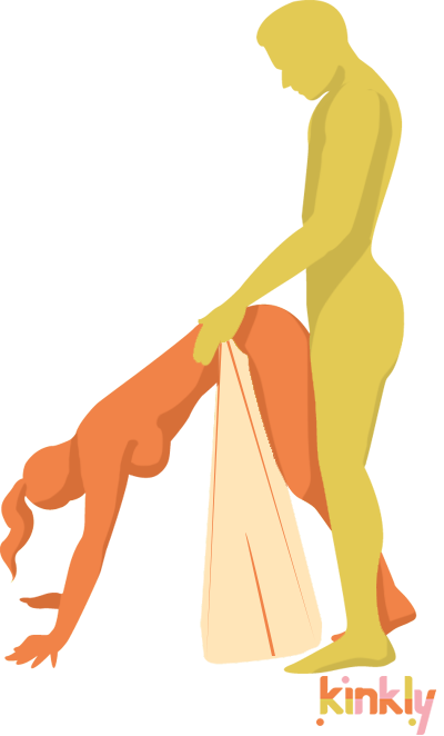 Illustration shows the Liberator Ramp in use. The Liberator Ramp is set up vertically with the thin edge in the air. The receiving partner is leaning over the Ramp and using it as a stabilizer to keep their balance. The penetrating partner is standing behind to penetrate. | Kinkly Shop