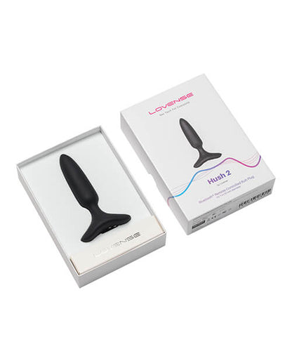 The Lovense Hush 2 resting inside of its packaging tray, shown next to the outer box | Kinkly Shop