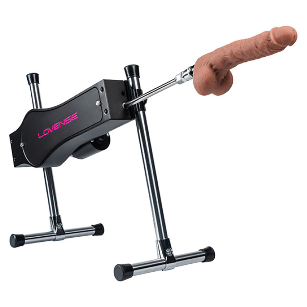 Close-up of the front of the included dildo. It is a realistic-looking dildo with a very pronounced and circumsized head, testicles, and a texture shaft. It is connected to the sex machine. | Kinkly Shop