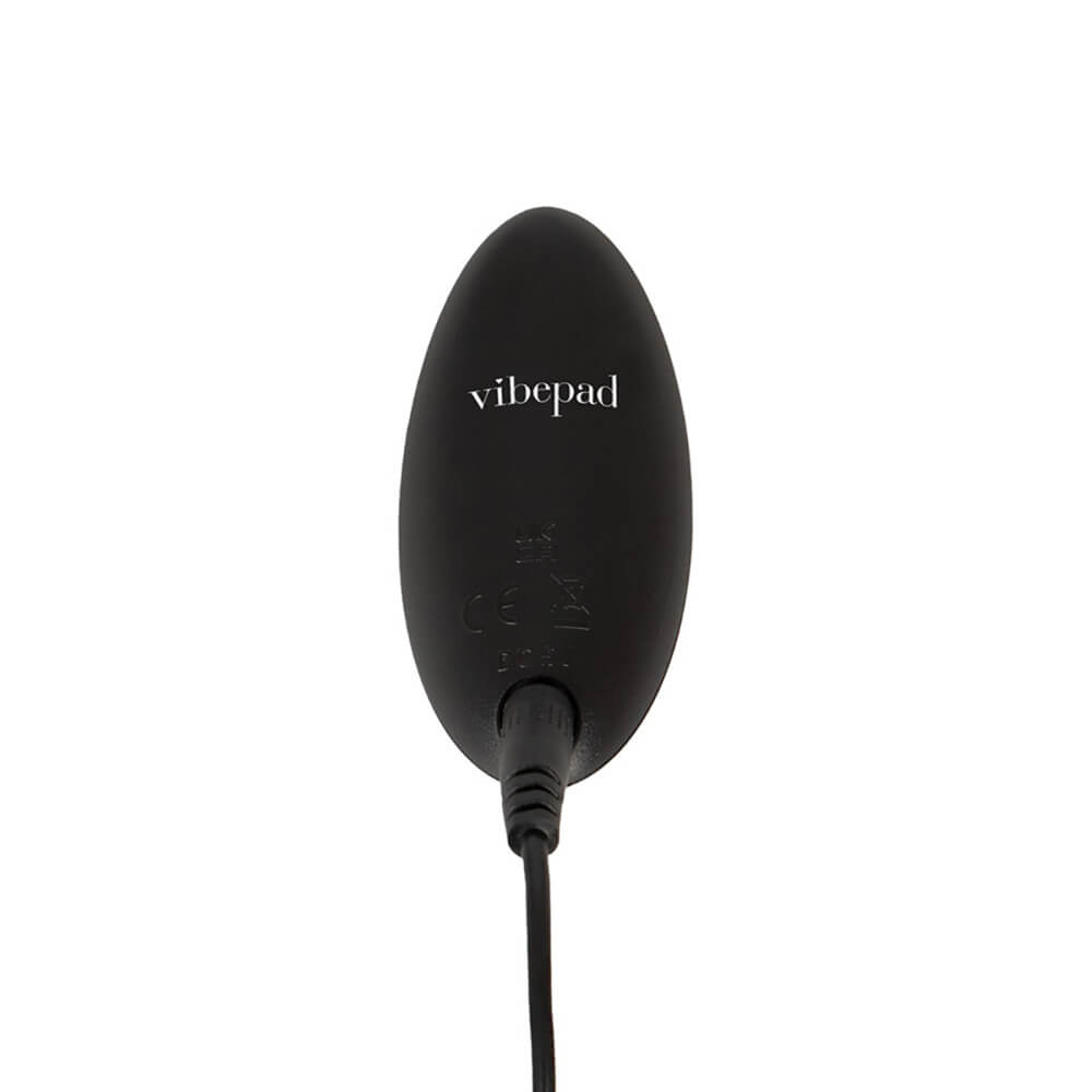 Close-up of the back-side of the Orion VibePad 3 remote. The charging cord is plugged into it, showcasing the remote control's rechargeable design. | Kinkly Shop