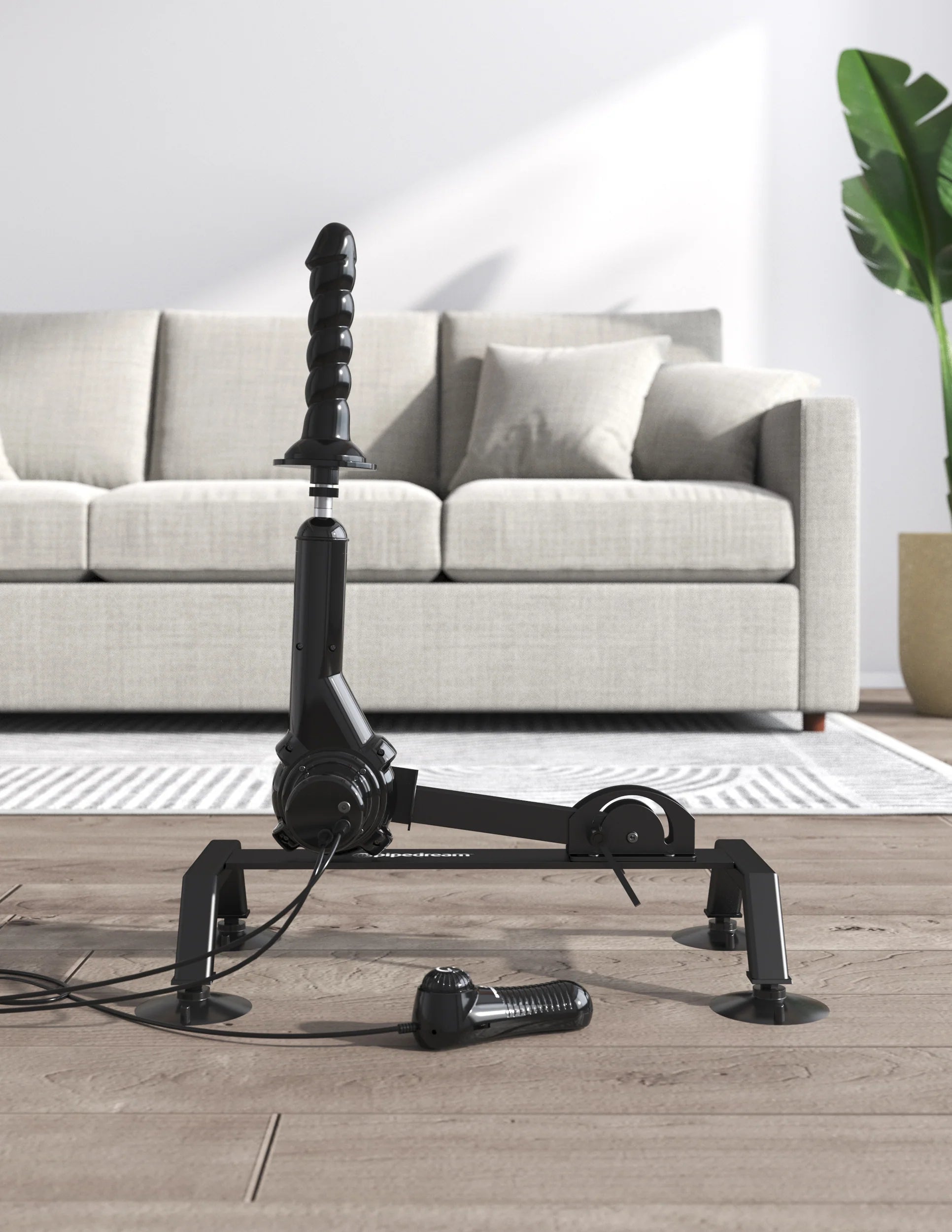 The Body Dock Pro Suction-Cup Machine in front of the couch. The dildo is positioned towards the ceiling, showcasing positioning potential of the machine. | Kinkly Shop