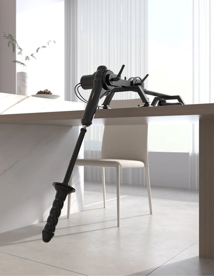 The Body Dock Pro Suction-Cup Machine is sitting on a desk with the thrusting dildo pointed towards the ground. | Kinkly Shop