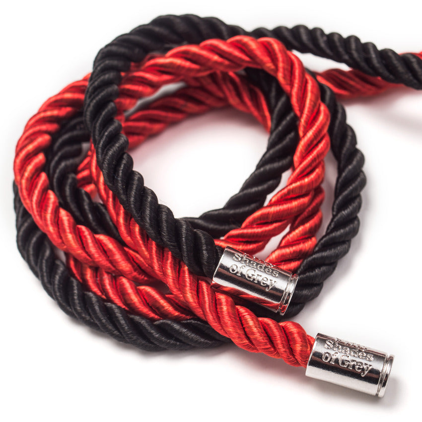Close-up on a pile of the ropes together, showcasing the metal endcaps that have the "Fifty Shades of Grey" etched into them. | Kinkly Shop