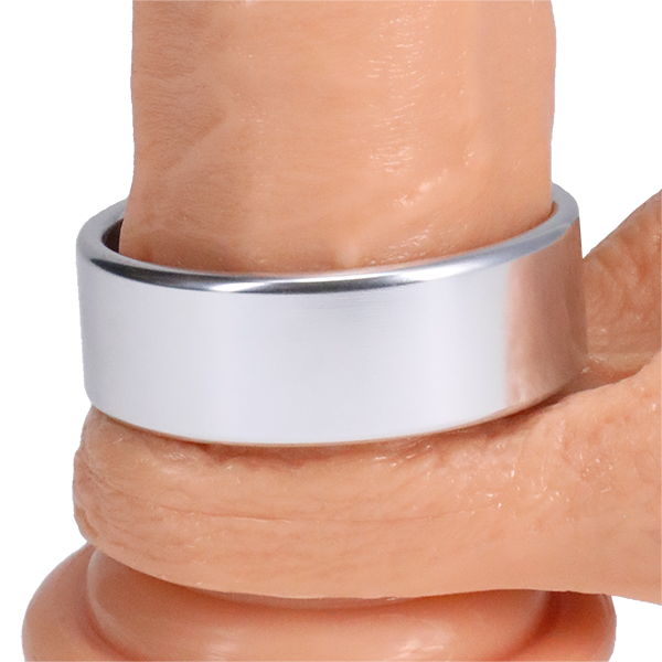 The Rock Solid Brushed Alloy in XL wrapped around the base of a dildo | Kinkly Shop