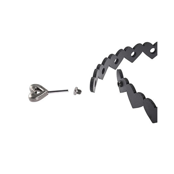 The heart-shaped hex code key shown unlocking the two sides of the Sportsheets Heart Day Collar from one another. There's no clear buckle on the collar; just the discreet hex key lock spot. | Kinkly Shop
