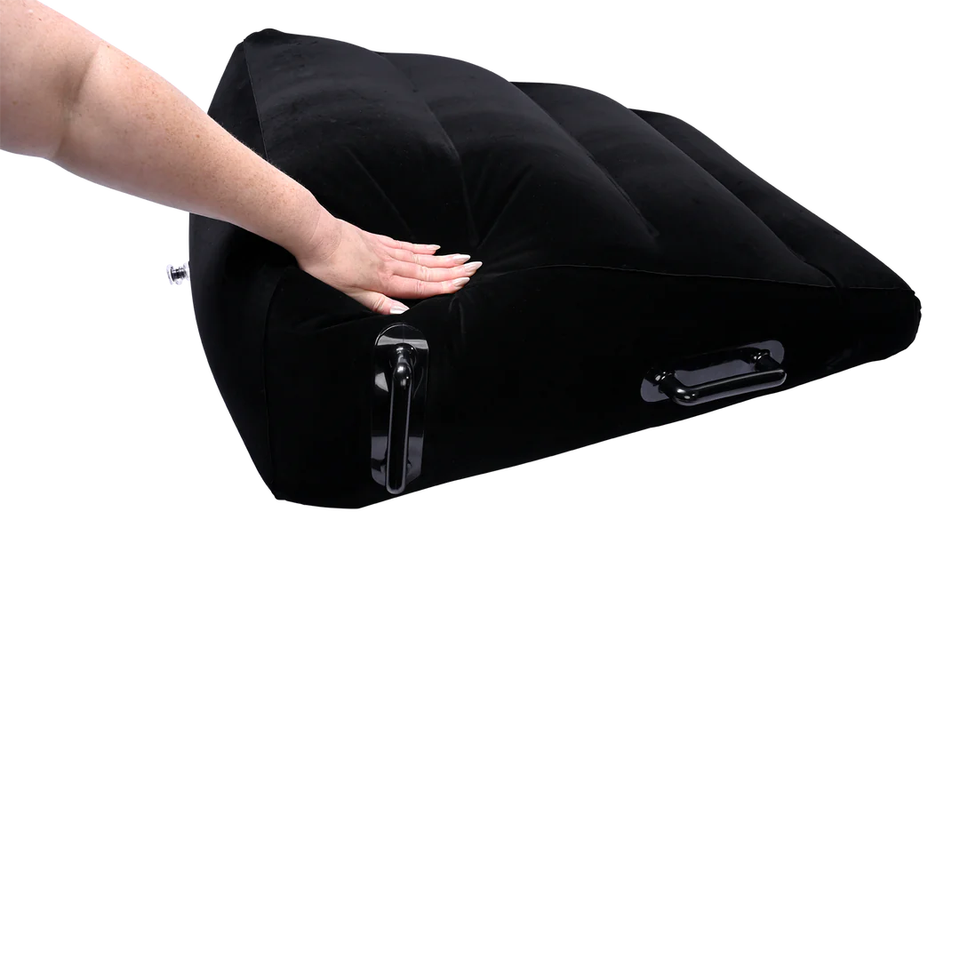 A hand presses down on the surface of the Sportsheets Inflatable Positioner Plus. The furniture compresses under the person's hand pressure more than if it would if it was a high-density foam. | Kinkly Shop