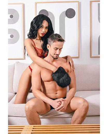 A couple is sitting on their underwear on a couch. One partner is wearing the Sportsheets Spiked Sensory Mitt on their hand. | Kinkly Shop