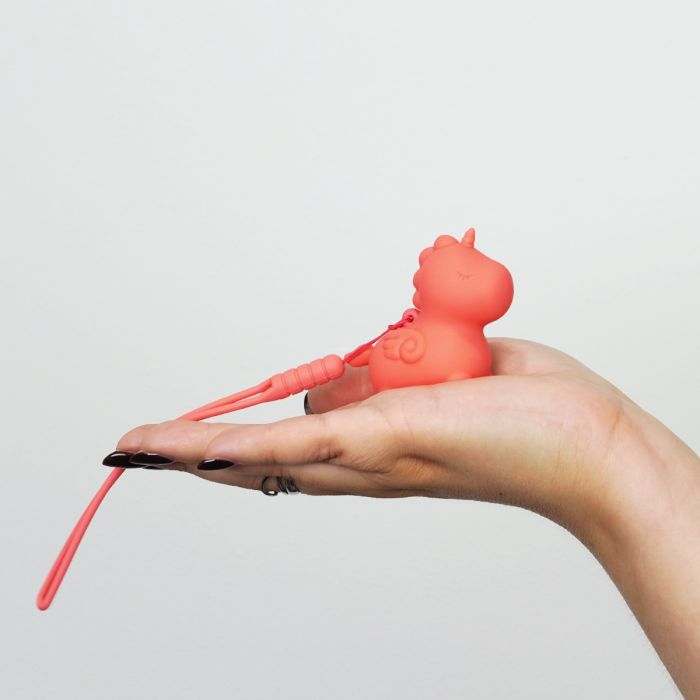 The Unihorns Mini Peachy Pony rests on top of someone's open, outstretched palm. The vibrator looks very small in their hand. | KinKly Shop