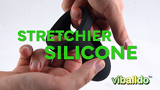 A person is gripping the base ring of the ViBalldo. They are pulling, showcasing the wide stretch of the new, stretchier silicone on the ViBalldo. It looks like it could wrap around a wrist at the widest stretch. | Kinkly Shop