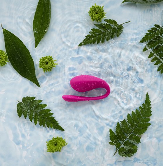 The We-Vibe Jive 2 vibrator inside a pool of water with leaves spread out all over the surface of the water. | Kinkly Shop