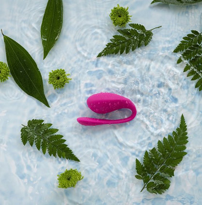 The We-Vibe Jive 2 vibrator inside a pool of water with leaves spread out all over the surface of the water. | Kinkly Shop