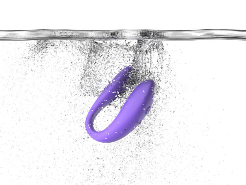 The We-Vibe Sync Go dropped into a pool of water, bubbles everywhere, showcasing its waterproof capabilities. | Kinkly Shop