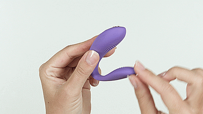 GIF showcases a person's two hands manipulating the We-Vibe Sync Go. They are pulling on the insertable end of the vibrator, showing as the insertable end flexs freely, allowing it to fit a wide variety of anatomies. | Kinkly Shop