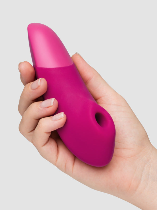 A person holds the Womanizer Enhance in the palm of their hand. The toy is slightly longer than the palm of their hand but looks very comfortable to grip. | Kinkly Shop