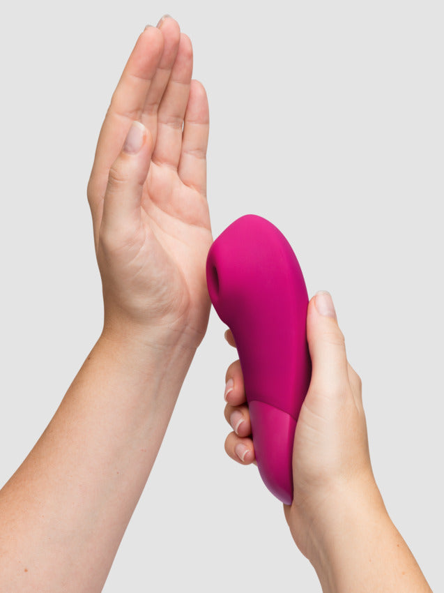 A person holds the hole of the Womanizer Enhance up against their palm. The vibrator looks like it has a relatively large air suction hole, but the tip does not look removable for easy cleaning. | Kinkly Shop